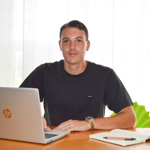 Daniele Brambilla, sviluppatore freelance specializzato nella creazione siti web, seduto alla scrivania con laptop, pronto a lavorare al prossimo progetto digitale.